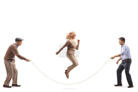 Foto de Hombres sosteniendo una cuerda y una mujer madura saltando aislados sobre fondo blanco - Imagen libre de derechos