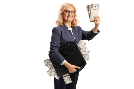 Téléchargez les photos : Riche femme d'affaires mature tenant une mallette pleine d'argent isolé sur fond blanc - en image libre de droit