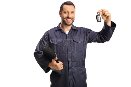 Photo for Car mechanic holding a clipboard and keys isolated on white background - Royalty Free Image
