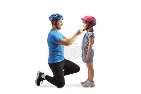 Photo for Father and daughter getting ready for a bicycle ride and putting helmets on isolated on white background - Royalty Free Image