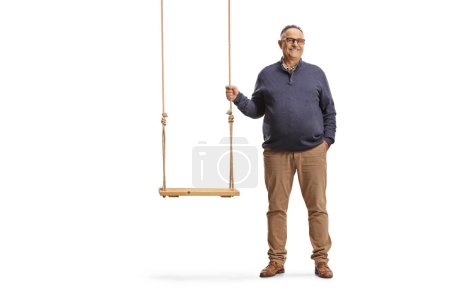 Téléchargez les photos : Homme mûr debout à côté d'une balançoire en bois isolé sur fond blanc - en image libre de droit