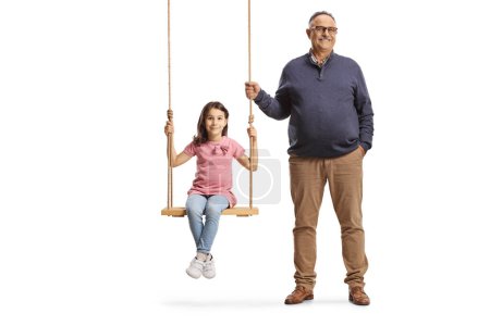 Foto de Abuelo de pie junto a la chica en un columpio de madera aislado sobre fondo blanco - Imagen libre de derechos