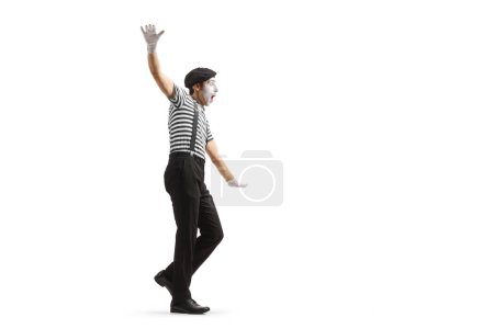 Photo for Full length profile shot of a mime walking and balancing isolated on white background - Royalty Free Image