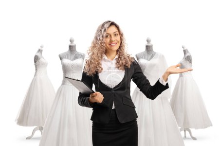 Photo for Businesswoman holding documents and gesturing welcome at a bridal shop isolated on white background - Royalty Free Image