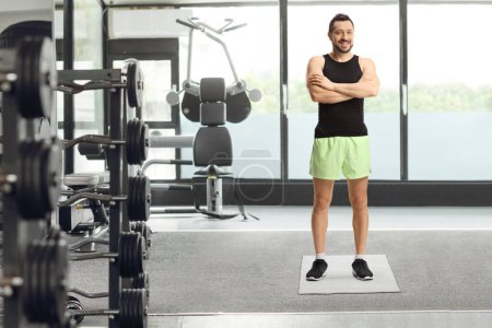 Photo for Full length portrait of a young man in sportswear posing inside a gym - Royalty Free Image