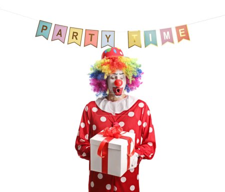 Téléchargez les photos : Clown tenant une boîte cadeau sous des drapeaux avec le temps de partie de texte isolé sur fond blanc - en image libre de droit