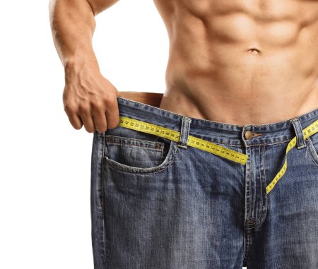Foto de Hombre musculoso sin camisa que usa un jeans de gran tamaño después de la pérdida de peso aislado en el fondo blanco - Imagen libre de derechos