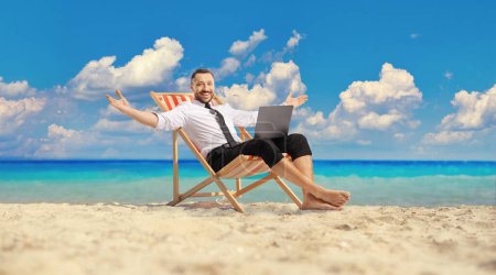 Photo for Bussinesman sitting on a deck chair and working remotely at the beach - Royalty Free Image