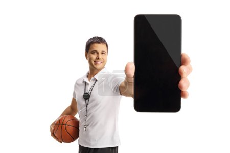 Photo for Basketball coach holding a ball and showing a smartphone isolated on white background - Royalty Free Image