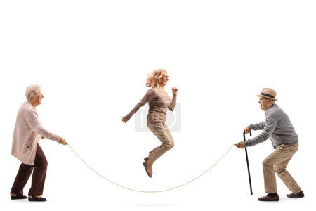 Foto de Foto de perfil de longitud completa de una mujer madura saltando una cuerda aislada sobre fondo blanco - Imagen libre de derechos