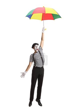 Photo for Mime flying and holding a colorful umbrella isolated on white background - Royalty Free Image