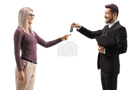 Téléchargez les photos : Homme d'affaires donnant des clés de voiture à une jeune femme isolée sur fond blanc - en image libre de droit