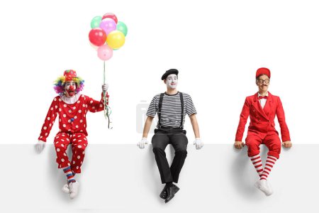 Téléchargez les photos : Clown, mime et un artiste assis sur une bannière blanche isolé sur fond blanc - en image libre de droit
