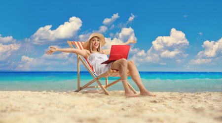 Téléchargez les photos : Jeune femme assise sur une chaise de plage avec un ordinateur portable et s'amuser - en image libre de droit