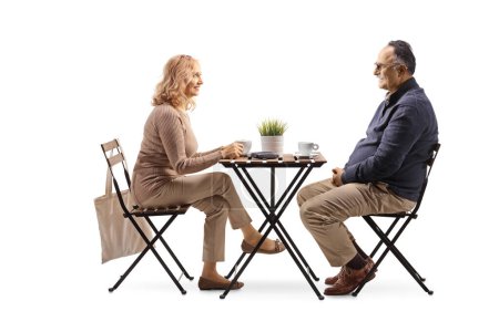 Téléchargez les photos : Full length profile shot of a mature man and woman at a coffee table isolated on white backgroun - en image libre de droit