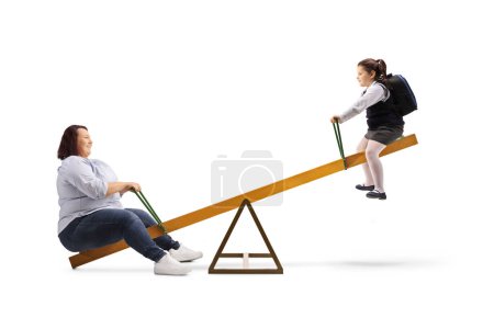 Téléchargez les photos : Corpulent mother playing on a seesaw with her daughter isolated on white background - en image libre de droit