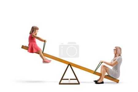Photo for Mother playing on a seesaw with a little girl isolated on white background - Royalty Free Image