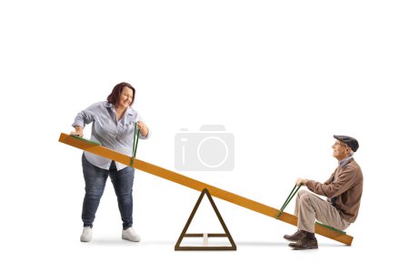 Photo for Overweight woman lifting an elderly man on a seesaw isolated on white background - Royalty Free Image