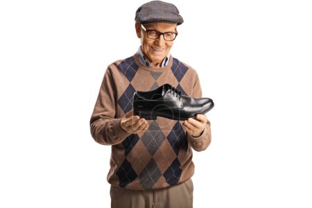 Téléchargez les photos : Elderly man holding a black leather shoe isolated on white background - en image libre de droit