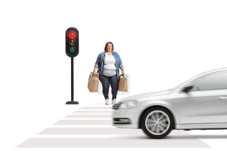 Téléchargez les photos : Full length portrait of a corpulent woman with grocery bags waiting at traffic lights isolated on white background - en image libre de droit