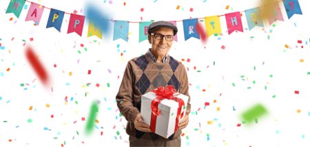 Téléchargez les photos : Smiling elderly man holding a present box under birthday flags isolated on white backgroun - en image libre de droit