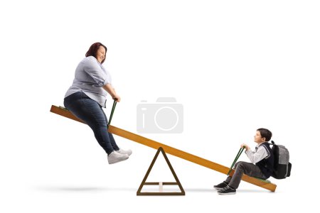 Photo for Woman and a schoolboy playing on a seesaw isolated on white background - Royalty Free Image
