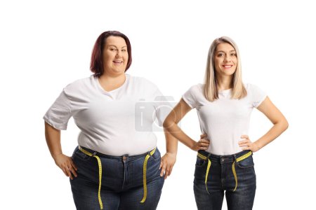 Foto de Young slim and overweight woman in jeans with a measuring tape around waist isolated on white background - Imagen libre de derechos