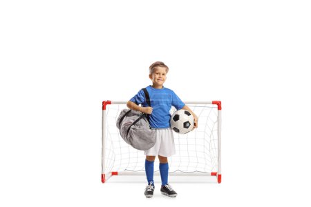 Photo for Boy with a football and sports bag standing in front of a mini goal isolated on white backgroun - Royalty Free Image