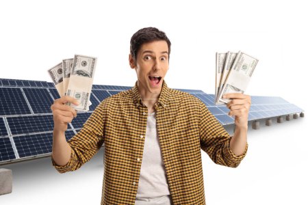 Photo for Excited young man holding cash at a solar farm isolated on white background - Royalty Free Image