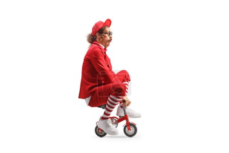 Foto de Comediante montando una pequeña bicicleta roja aislada sobre fondo blanco - Imagen libre de derechos