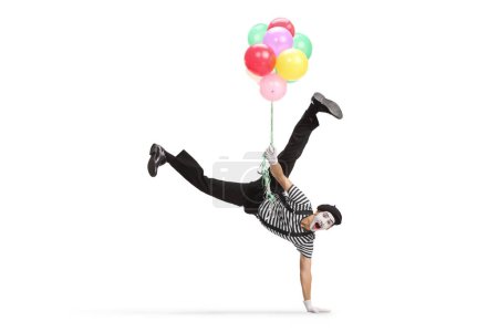 Photo for Mime doing a handstand and holding a bunch of balloons isolated on white background - Royalty Free Image