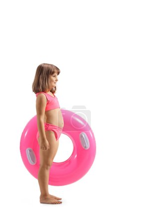 Foto de Foto de perfil completo de una chica en traje de baño con un anillo de baño de goma rosa aislado sobre fondo blanco - Imagen libre de derechos