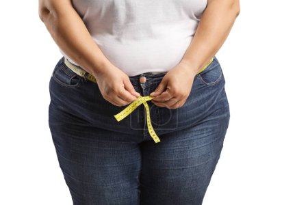 Foto de Mujer con sobrepeso que usa jeans y mide la cintura aislada sobre fondo blanco - Imagen libre de derechos