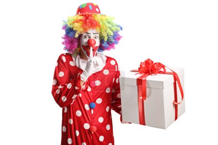 Photo for Clown with a birthday present making a finger mouth shush sign isolated on white background - Royalty Free Image