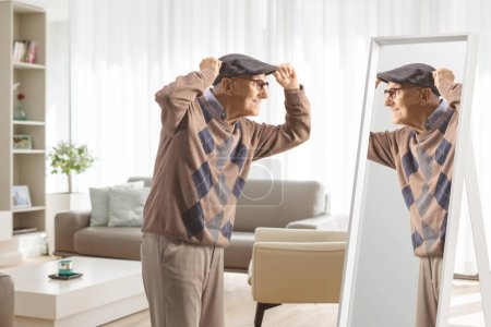 Téléchargez les photos : Un vieux monsieur se prépare devant un miroir à la maison - en image libre de droit