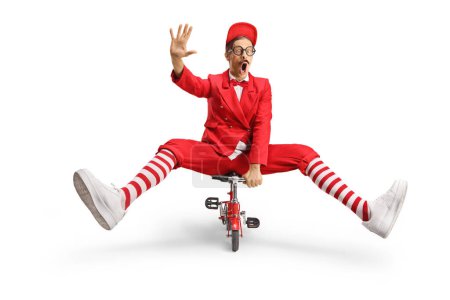 Animateur en costume rouge chevauchant un petit vélo et agitant isolé sur fond blanc