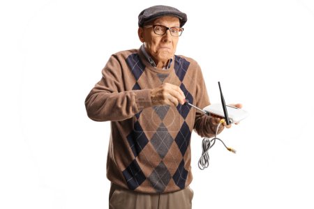 Foto de Viejo gracioso tratando de arreglar el router con un destornillador aislado sobre fondo blanco - Imagen libre de derechos