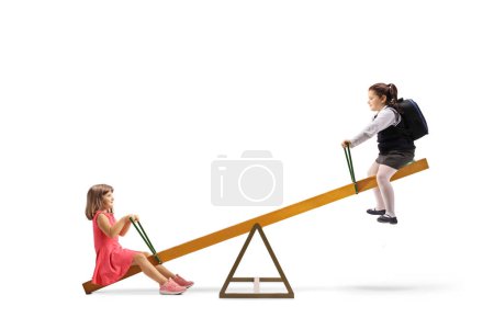 Photo for Two girls playing on a seesaw isolated on white background - Royalty Free Image