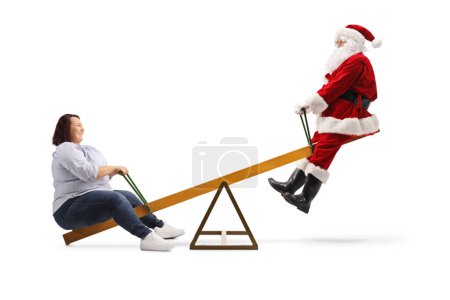 Téléchargez les photos : Joyeux Père Noël sur une balançoire avec une jeune femme corpulente isolée sur fond blanc - en image libre de droit