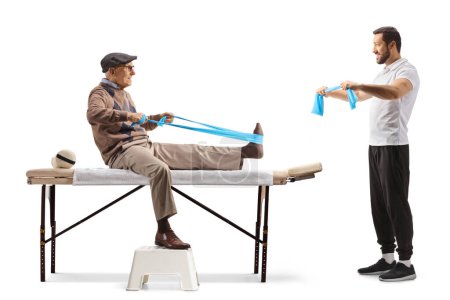 Téléchargez les photos : Homme âgé faisant de l'exercice avec une bande élastique avec un thérapeute isolé sur fond blanc - en image libre de droit