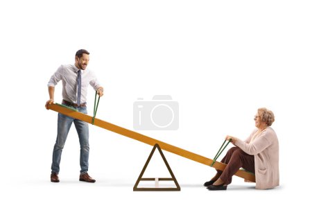 Photo for Man lifting an elderly woman on a seesaw isolated on white background - Royalty Free Image