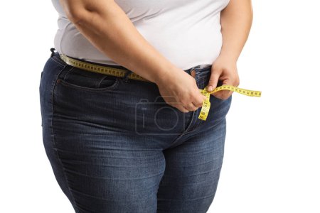 Foto de Mujer corpulenta que usa jeans y mide la cintura aislada sobre fondo blanco - Imagen libre de derechos