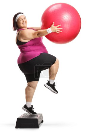 Téléchargez les photos : Positif femme plus taille exercice aérobie étape avec une boule finesse isolé sur fond blanc - en image libre de droit
