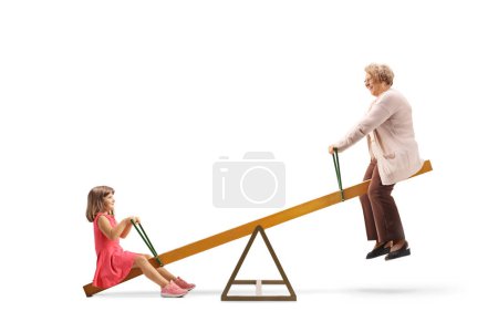 Photo for Grandmother and granddaughter swinging on a seesaw isolated on white background - Royalty Free Image