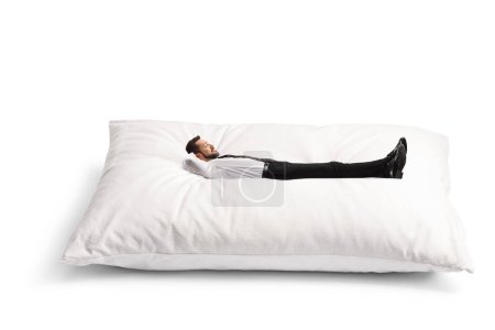 Foto de Empresario acostado sobre una gran almohada aislada sobre fondo blanco - Imagen libre de derechos