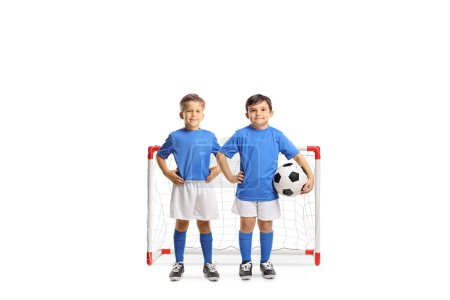Photo for Little boys in football clothes posing in front of a mini goal isolated on white backgroun - Royalty Free Image