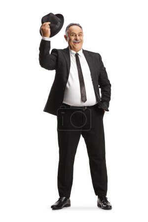 Téléchargez les photos : Portrait complet d'un gentleman mature saluant avec un chapeau isolé sur fond blanc - en image libre de droit