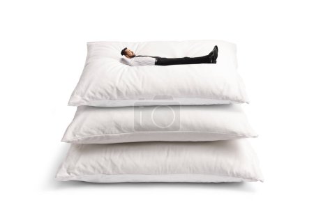 Téléchargez les photos : Homme couché sur un tas d'oreillers avec des vêtements et des chaussures isolés sur fond blanc - en image libre de droit