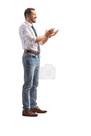 Téléchargez les photos : Plan de profil pleine longueur d'un jeune homme applaudissant avec les mains isolées sur fond blanc - en image libre de droit