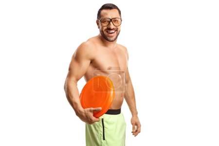 Téléchargez les photos : Joyeux jeune homme en maillot de bain tenant un disque volant en plastique isolé sur fond blanc - en image libre de droit